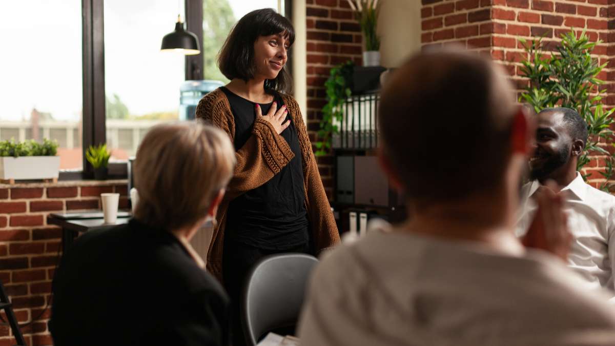 Female patient during alcohol detox sharing personal experiences in group therapy.