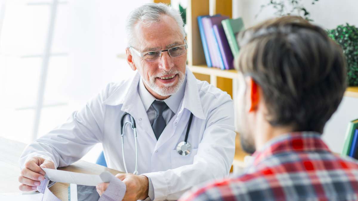 Medical professional during consultation with male patient going through drug detox, as part of medically-assisted treatment.