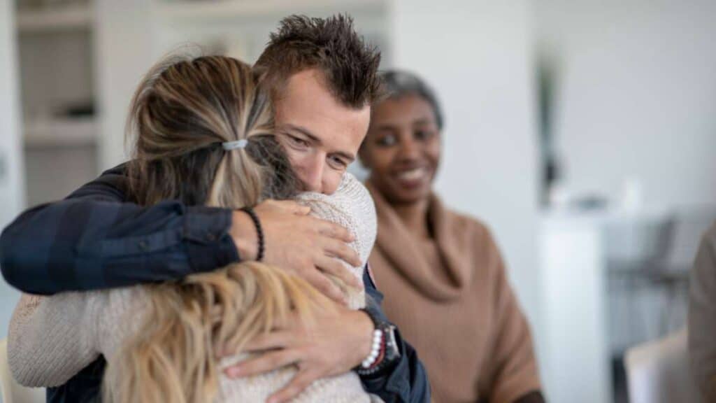 Supportive woman hugging loved one on his journey to recovery through heroin detox