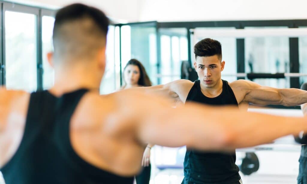 Man intensely working out in a gym, illustrating concerns related to muscle dysmorphia and body dysmorphia.